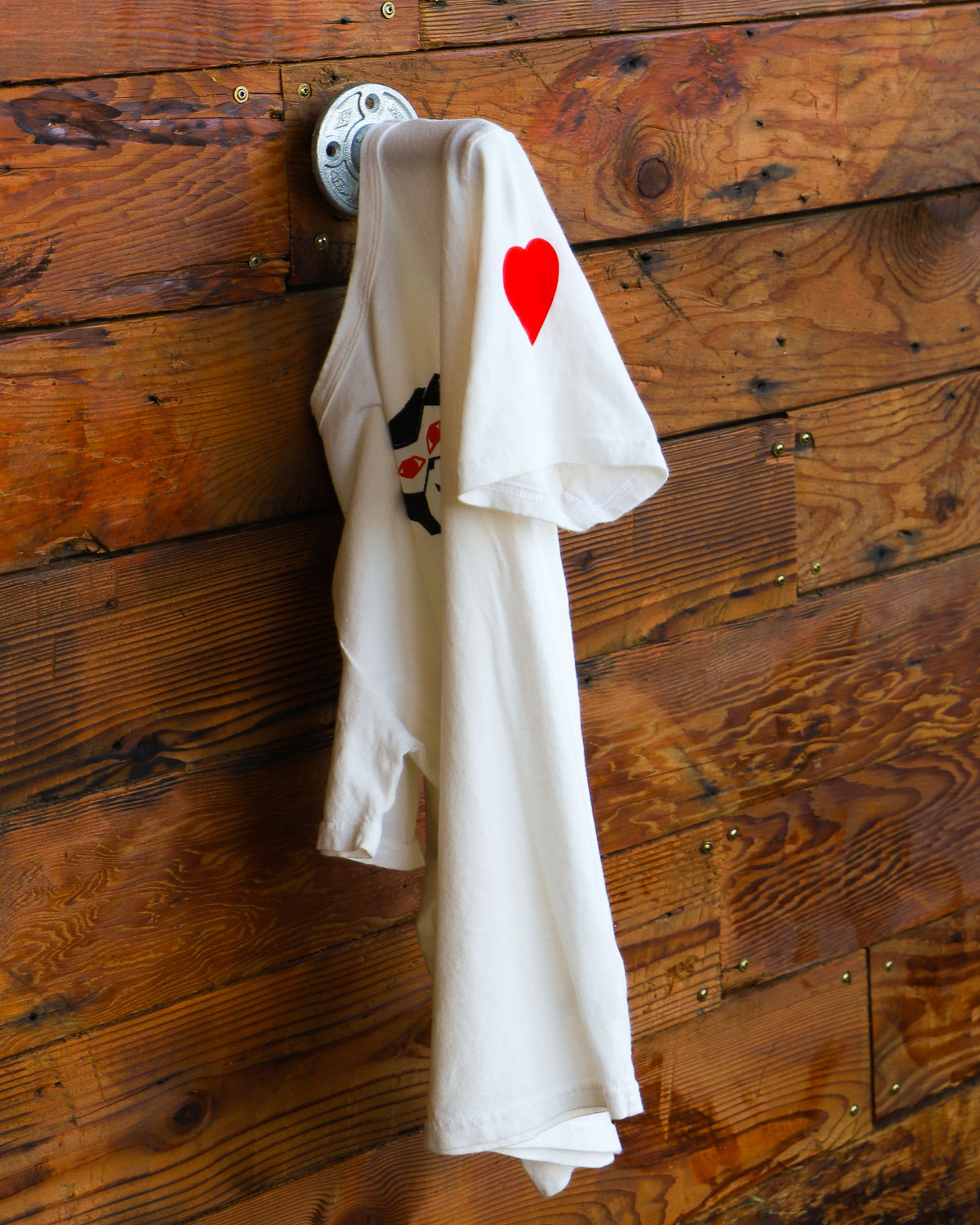 Vintage white see evil t-shirt hanging on wood wall