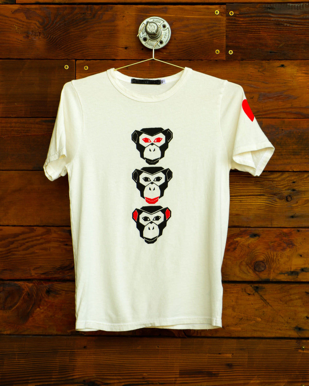 Vintage white see evil t-shirt hanging on wood wall