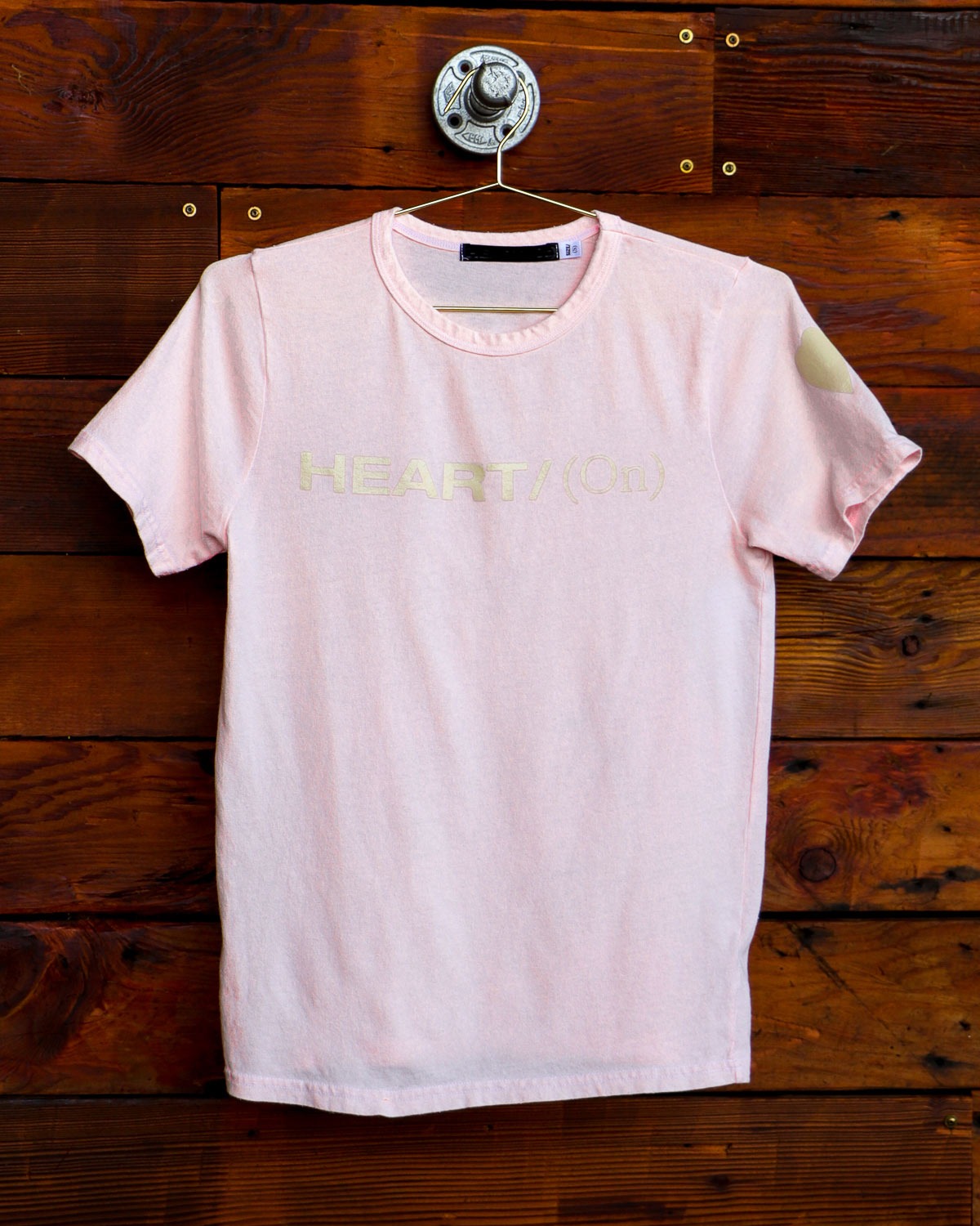 Light pink Heart On logo t-shirt hanging on wood wall