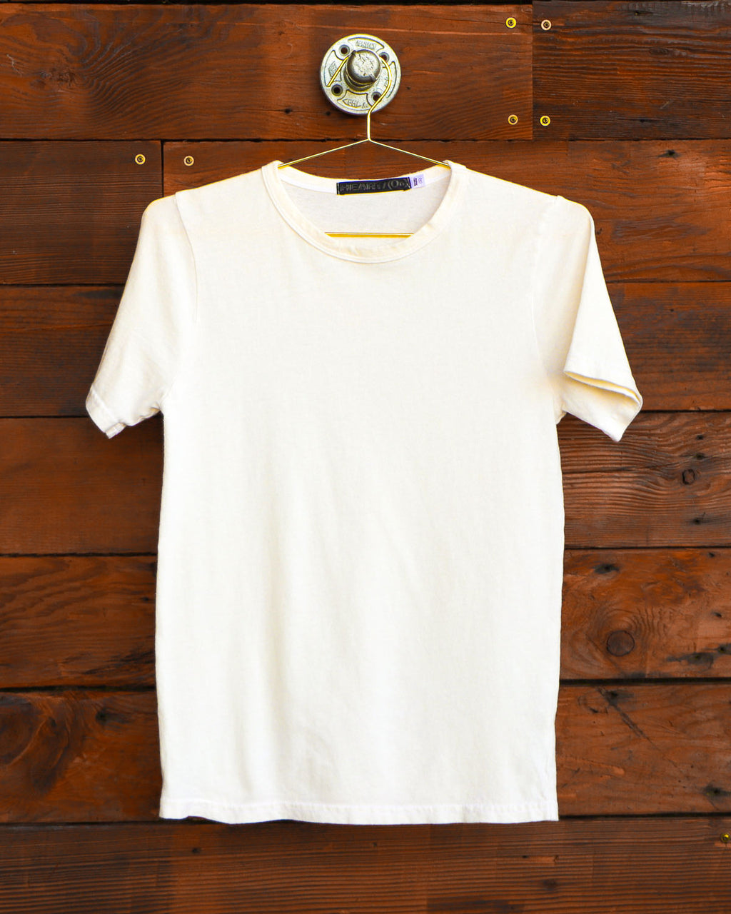 Vintage white t-shirt hanging on wood wall