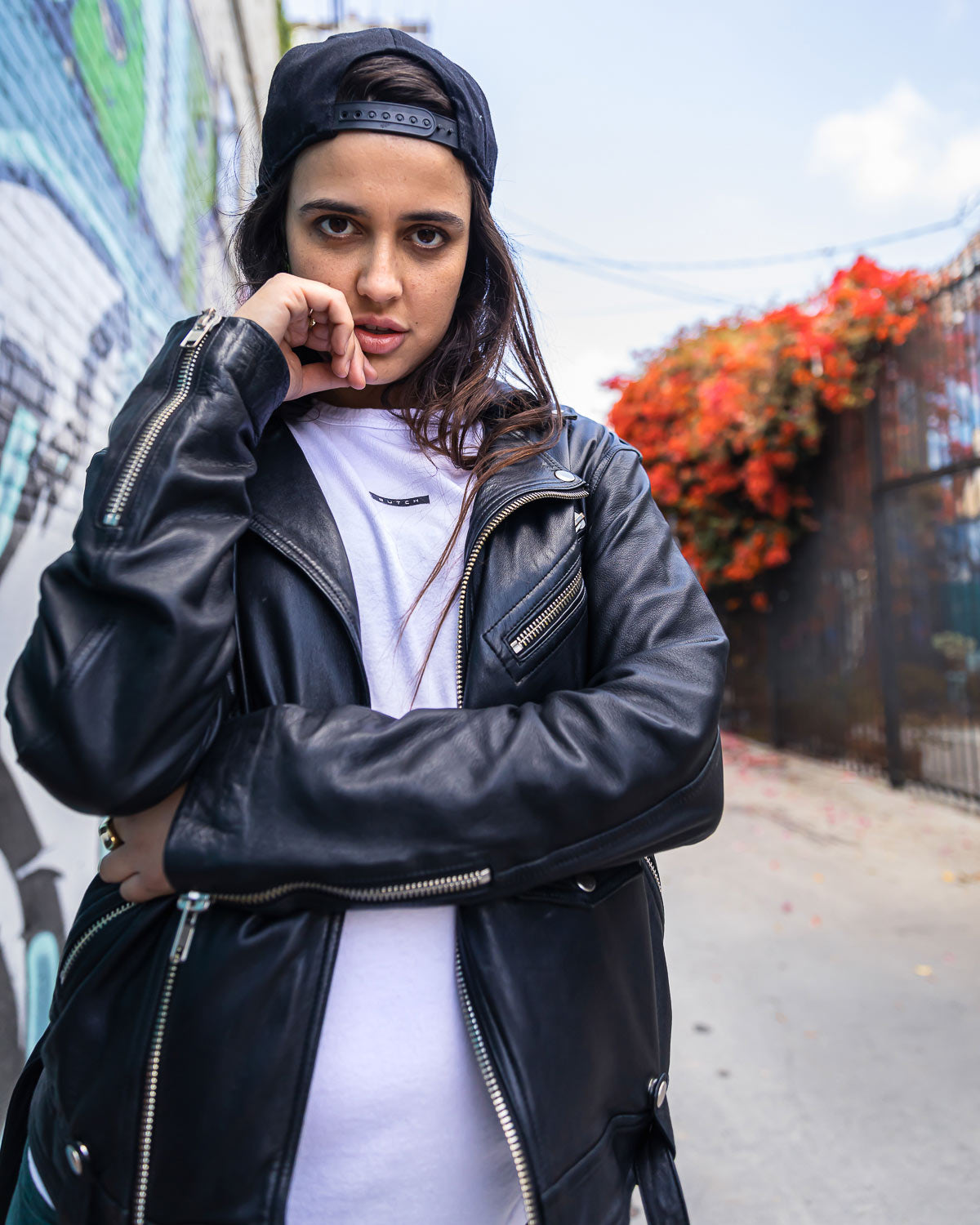 Model in leather jacket wearing butch white t-shirt