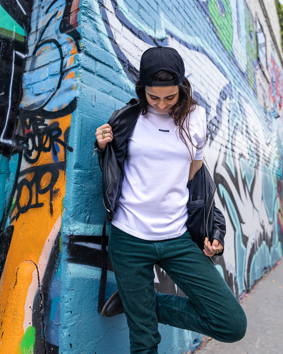 Model wearing white butch label shirt against graffiti