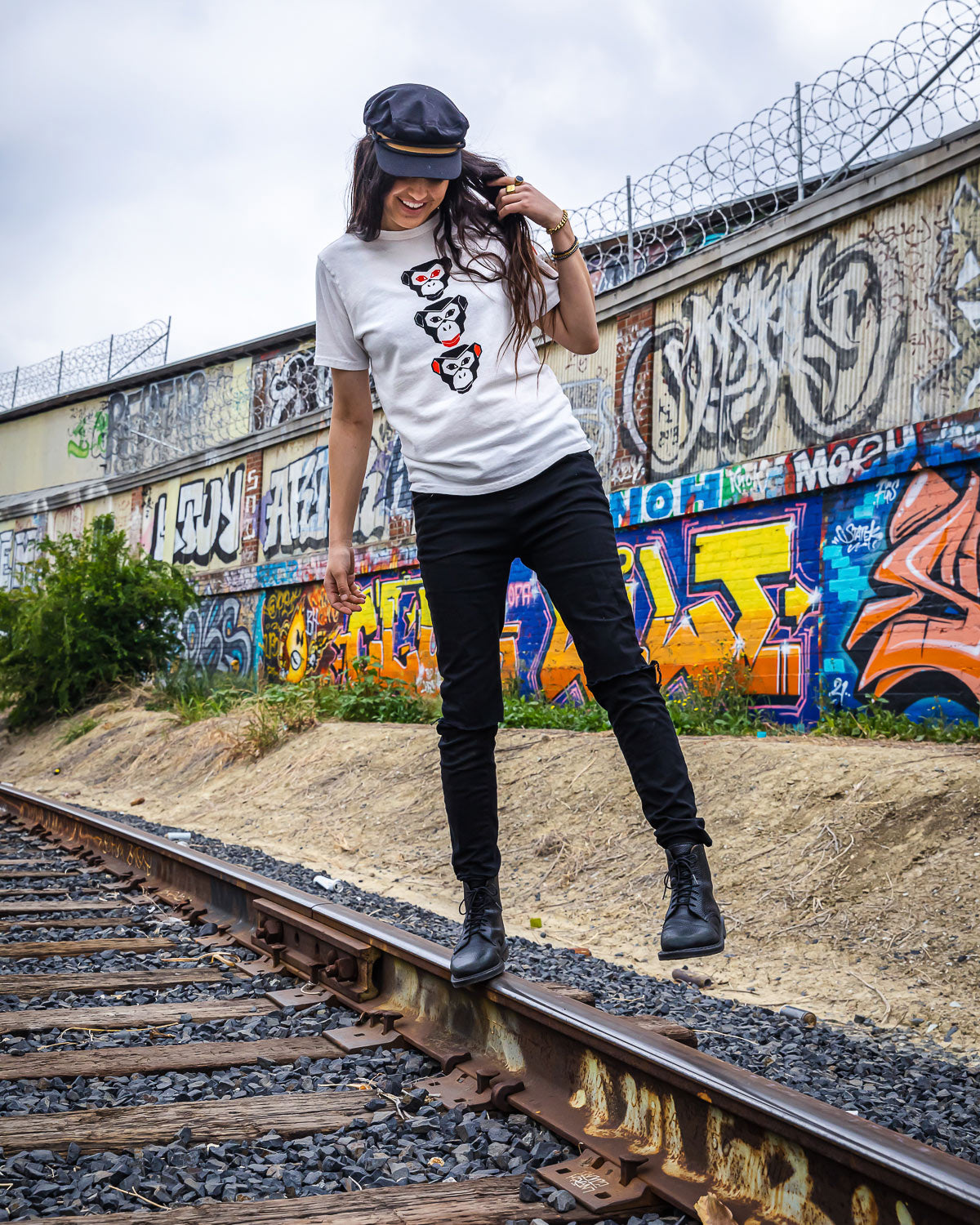 Model wearing Vintage white see evil t-shirt on train tracks