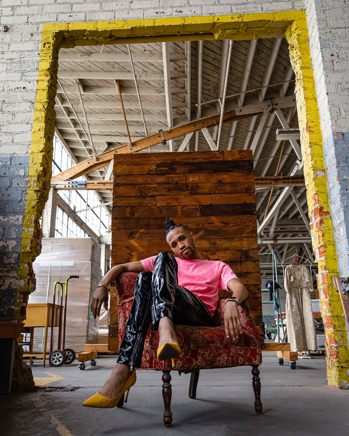 Male model in heels wearing bright salmon hand dyed tie dye t-shirt